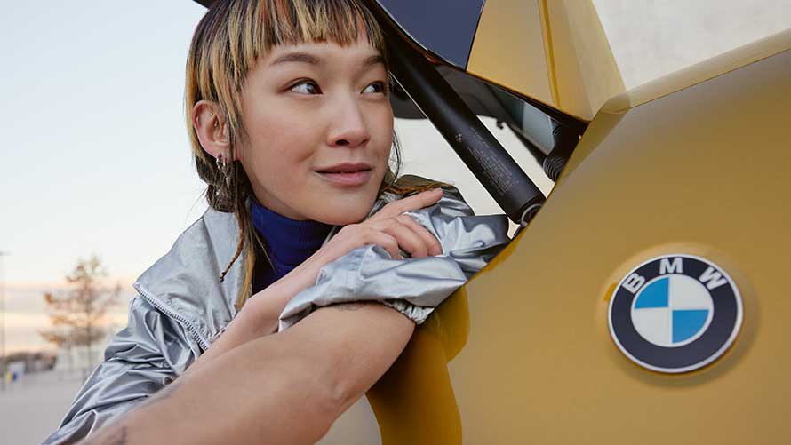 Kobieta i mężczyzna spoglądają w przestrzeń oparci o samochód